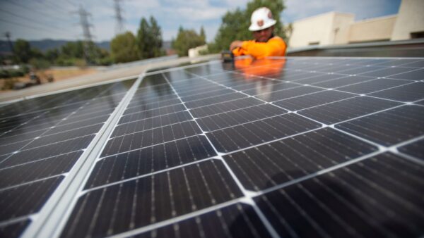solar panel A man in a hardhat is shown installing or inspecting a solar panel.