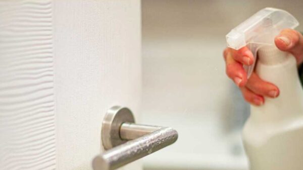 Alternative Cleaning Products A woman is disinfecting a door handle with an alternative cleaning product made from safe household ingredients.